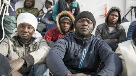 Menschen sitzen an Bord des deutschen Rettungsschiffes Sea-Eye vor Malta / © Rene Rossignaud (dpa)