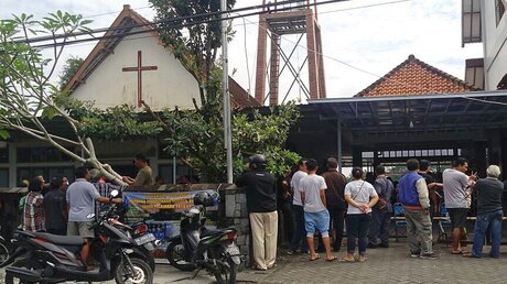 Menschen stehen nach einem Schwertangriff vor einer indonesischer Kirche / © Slamet Riyadi (dpa)