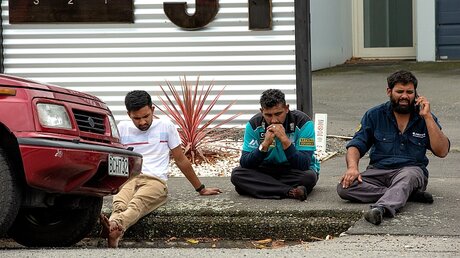 Nach den Schüssen in der Moschee sitzen trauernde Menschen auf der Straße / © Martin Hunter (dpa)