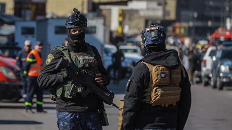 Nach Selbstmordattentat in Bagdad: Bewaffnete irakische Sicherheitskräfte stehen am Ort des tödlichen Anschlags. / © Ameer Al Mohammedaw (dpa)