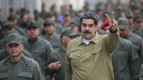 Nicolas Maduro (r), umgeben von Soldaten / © Marcelo Garcia (dpa)