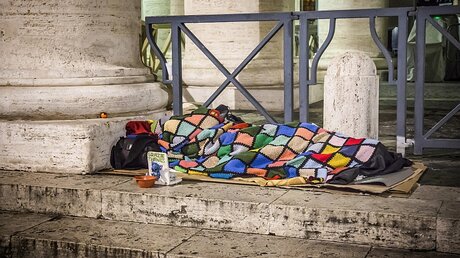 Ein Wohnungsloser am Petersplatz schläft auf Pappkartons / © Stefano dal Pozzolo (KNA)