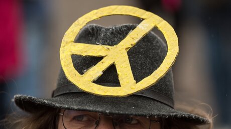 Ostermarsch: Ein Mann hat sich das Zeichen der Friedensbewegung an seinen Hut gepinnt.  / © Boris Roessler (dpa)