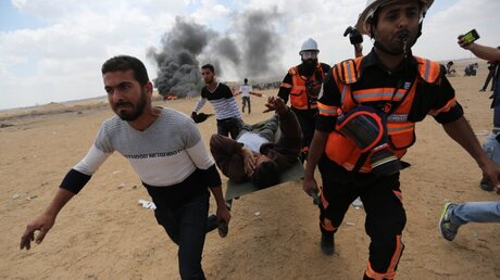Palästinenser tragen einen verletzten Demonstranten  / © Ashraf Amra/APA Images via ZUMA Wire (dpa)