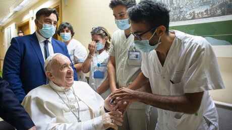 Papst Franziskus im Gespräch mit einem Krankenhausmitarbeiter in der Gemelli-Klinik / © Vatican Media/Romano Siciliani (KNA)