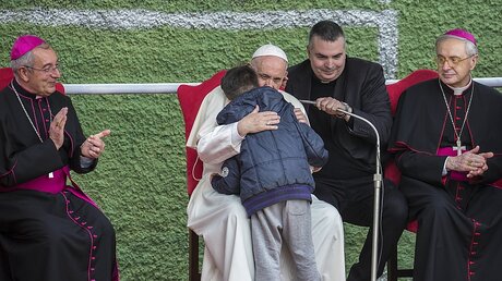 Papst Franziskus umarmt einen Jungen bei seinem Besuch im römischen Stadtteil Corviale / © Stefano dal Pozzolo (KNA)