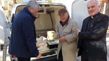  Almosenmeister Krajewski (l.) besucht einen Käse-Hersteller in Camerino  / © Presseamt des Heiligen Stuhls (dpa)