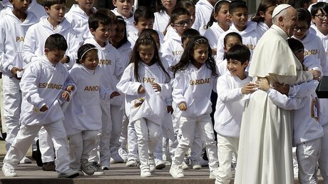 Papst Franziskus wird von Kindern in Bogota (Kolumbien) umarmt. / © Fernando Vergara (dpa)