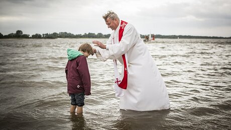 Pastor Wilm aus Hamburg St. Pauli tauft den jungen Wanja / © Philipp Reiss (epd)