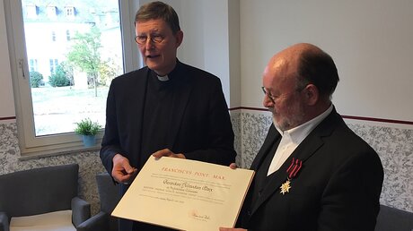 Kardinal Woelki überreicht Benjamin Marx die Ordensinsignien (Erzbistum Köln)