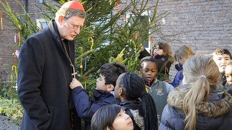 Neugierig betrachtet ein Schüler der KSG Heßhofstraße das Holzkreuz von Kardinal Woelki. (Erzbistum Köln)