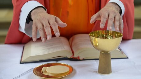 Ein Pfarrer segnet bei einer Eucharistiefeier in Offenbach die Gaben Brot und Wein (KNA)