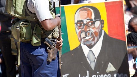 Polizist vor einem Porträt von Robert Mugabe / © Tsvangirayi Mukwazhi (dpa)