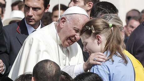 Papst Fransziskus begrüßt ein Kind während der Audienz  / © Giuseppe Lami (dpa)