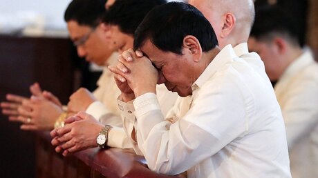 Philippinens Präsident Duterte (v.) im Gebet / © King Rodriguez / Ppd / Handout (dpa)