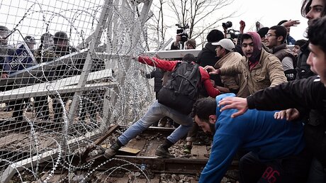 Migranten stürmen Grenzzaun / © Louisa Gouliamaki (dpa)