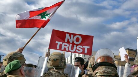 Regierungskritische Demonstranten mit einer Fahne und einem Plakat mit der Aufschrift "No Trust" (Kein Vertrauen) im Libanon / © Marwan Naamani (dpa)