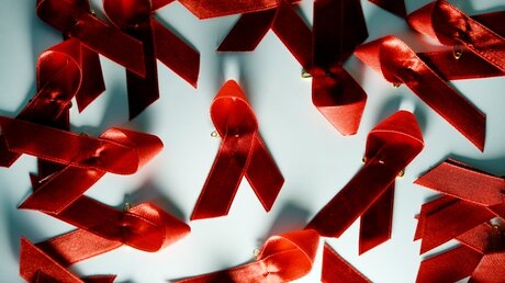Rote Schleife als Zeichen der Solidarität mit HIV-Infizierten / © Jens Kalaene (dpa)