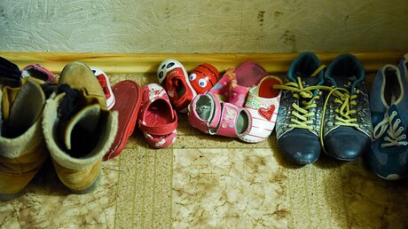 Aneinandergereihte Schuhe im Flur einer Flüchtlingsunterkunft im ukrainischen Kramatorsk.  / © Julia Rathcke (KNA)