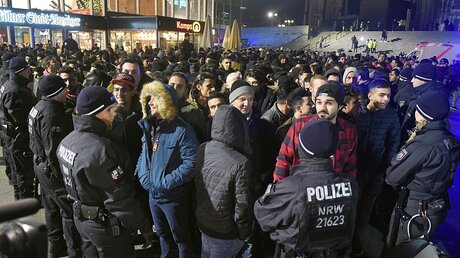 Polizisten umringen am 31.12.2016 vor dem Hauptbahnhof in Kölneine Gruppe südländisch aussehender Männer. / © Henning Kaiser (dpa)