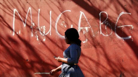 Simbabwe: Frau vor einer Mauer mit dem Graffitti-Schriftzug "Mugabe" / © Tsvangirayi Mukwazhi (dpa)