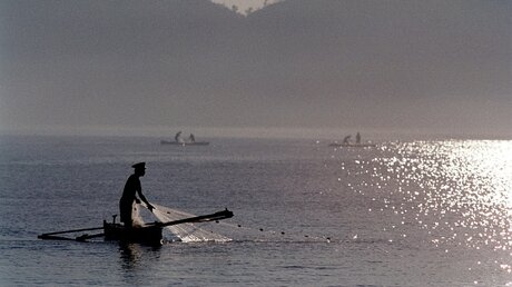 Sonnenaufgang am Strand von Dili - Fischer ziehen ihre Netze ein. (KNA)