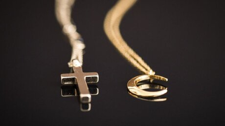 Das Kreuz und der Halbmond: Zeichen für das Christentum und den Islam / © Julia Steinbrecht (KNA)