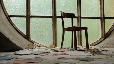 Symbolbild: Ein leerer Stuhl in einer verlassenen Kirche / © Lensw0rId (shutterstock)
