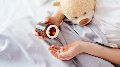 Symbolbild: Kind mit Tabletten / © Daniel Jedzura (shutterstock)