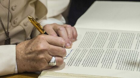 Symbolbild: Papst Franziskus signiert ein Dokument / © Osservatore Romano/Romano Siciliani (KNA)