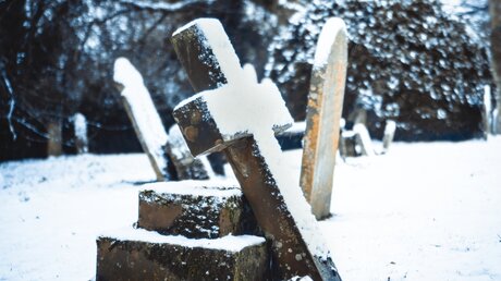 Symbolbild: Schneebedeckter Grabstein auf einem Friedhof / © Adam J Hague (shutterstock)