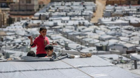 Syrische Kinder spielen auf dem Dach eines Flüchtlingslagers nordöstlich der libanesischen Hauptstadt Beirut / © Marwan Naamani (dpa)