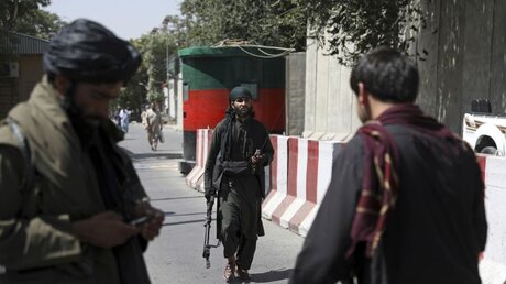 Taliban-Kämpfer stehen an einem Kontrollpunkt auf dem Weg zum afghanischen Außenministerium (dpa)