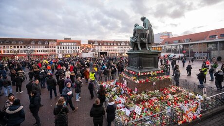 Trauernde stehen auf dem Hanauer Marktplatz, um die Gedenkfeier auf einer Videoleinwand zu sehen / © Andreas Arnold (dpa)