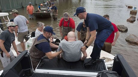 Mitarbeiter der US-Küstenwache und Freiwillige helfen in Houston (USA)  / © Ryan Dickinson (dpa)