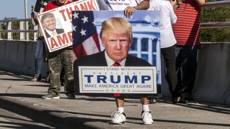  Trump-Anhänger warten auf die Autokolonne des Präsidenten der USA / © Damon Higgins (dpa)
