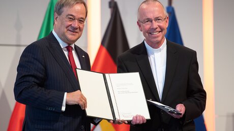 Verleihung des Landesverdienstordens von NRW-Ministerpräsident Laschet (l.) an Msgr. Kossen (r.)  / © Marius Becker (dpa)