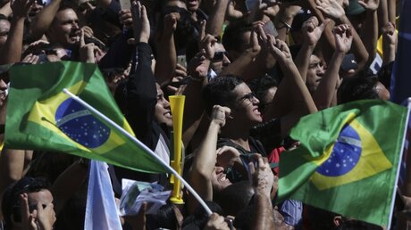 Vor der Wahl in Brasilien: Menschen jubeln bei einer Wahlveranstaltung / © Eraldo Peres (dpa)