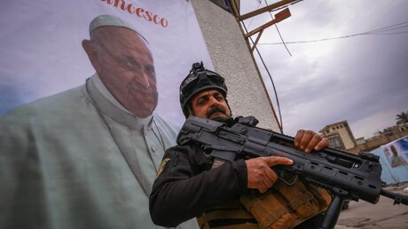 Vorbereitungen auf den Papstbesuch: Ein bewaffneter Polizist steht an einer Kirche inmitten einer Sicherheitskontrolle / © Ameer Al Mohammedaw (dpa)