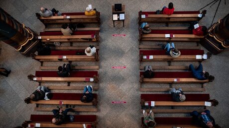 Wallfahrt in Kevelaer: Gottesdienstbesucher sitzen aufgrund der Corona-Pandemie mit Abstand zueinander auf Kirchenbänken / © Fabian Strauch (dpa)