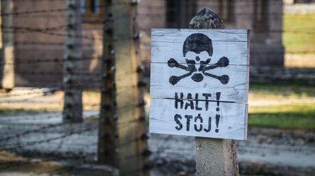 Warnschild vor der Gedenkstätte Auschwitz-Birkenau / © Hana Hanigerova (shutterstock)
