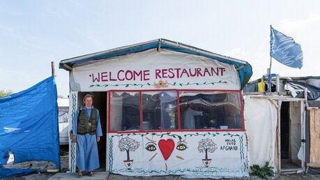 Bruder Johannes vor einem afghanischen Restaurant / ©  Elisabeth Schomaker (KNA)
