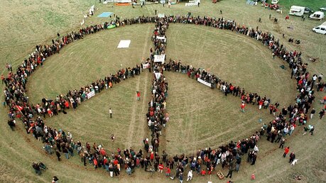 1998: Ostermarsch-Teilnehmer in Brandenburg stellen sich zu einem Peace-Zeichen auf / © Jens Büttner (dpa)