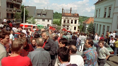 29.05.1993, Solingen: Vor dem abgebrannten Haus bekunden türkische und deutsche Bürger ihr Entsetzen / © Roland Scheidemann (dpa)