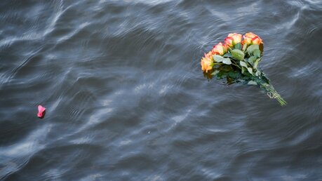 Blumen zum Gedenken an im Mittelmeer ertrunkene Flüchtlinge  / © Axel Heimken (dpa)