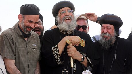 Kopten-Papst Tawadros II. (Mitte) lacht mit dem jordanischen Prinzen Ghazi bin Muhammad (l) / © Jamal Nasrallah (dpa)