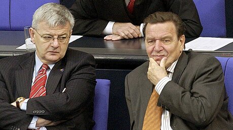 2003: Gerhard Schröder (r) verfolgt gemeinsam mit Joschka Fischer (l) und Peter Struck die Debatte im Bundestag. / © Tim Brakemeier (dpa)