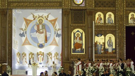 Diakone und Geistliche stehen am Altar der koptisch-orthodoxen Kathedrale der Geburt Christi in Kairo bei Beginn der Weihnachtsmesse. / © Ahmed Abdelfattah (dpa)