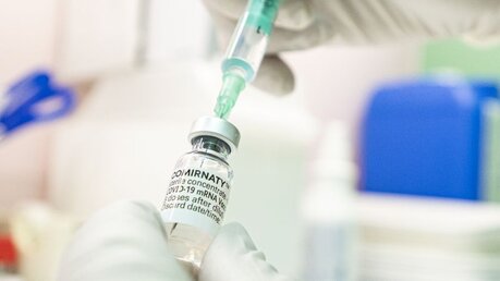 Ein Arzt zieht den Corona-Impfstoff Comirnaty von Biontech-Pfizer in eine Spritze / © Fabian Sommer (dpa)