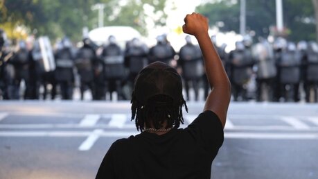 Ein Demonstrant streckt während eines Protests seine Faust in die Höhe / © Ben Gray (dpa)